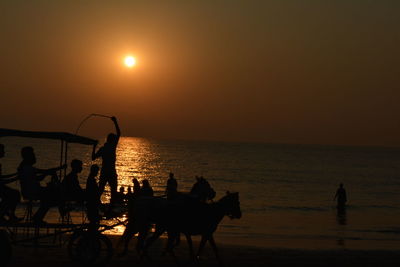 Silhouette people on beach during sunset