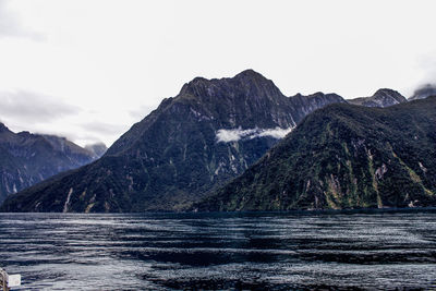 Scenic view of sea and mountains against sky