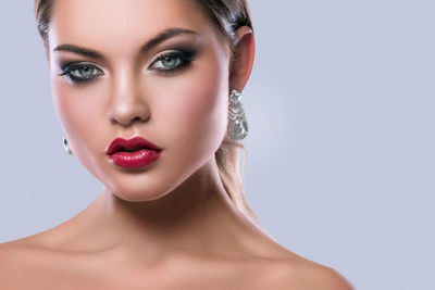Close-up of young woman against white background