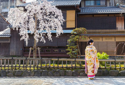 Woman with umbrella against building