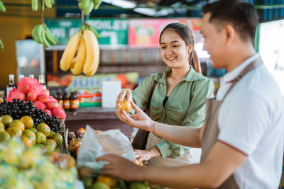 Portrait of woman holding fruits at market