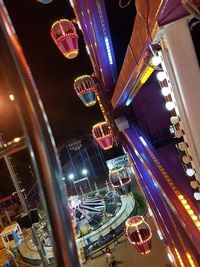 Low angle view of illuminated ferris wheel in city at night