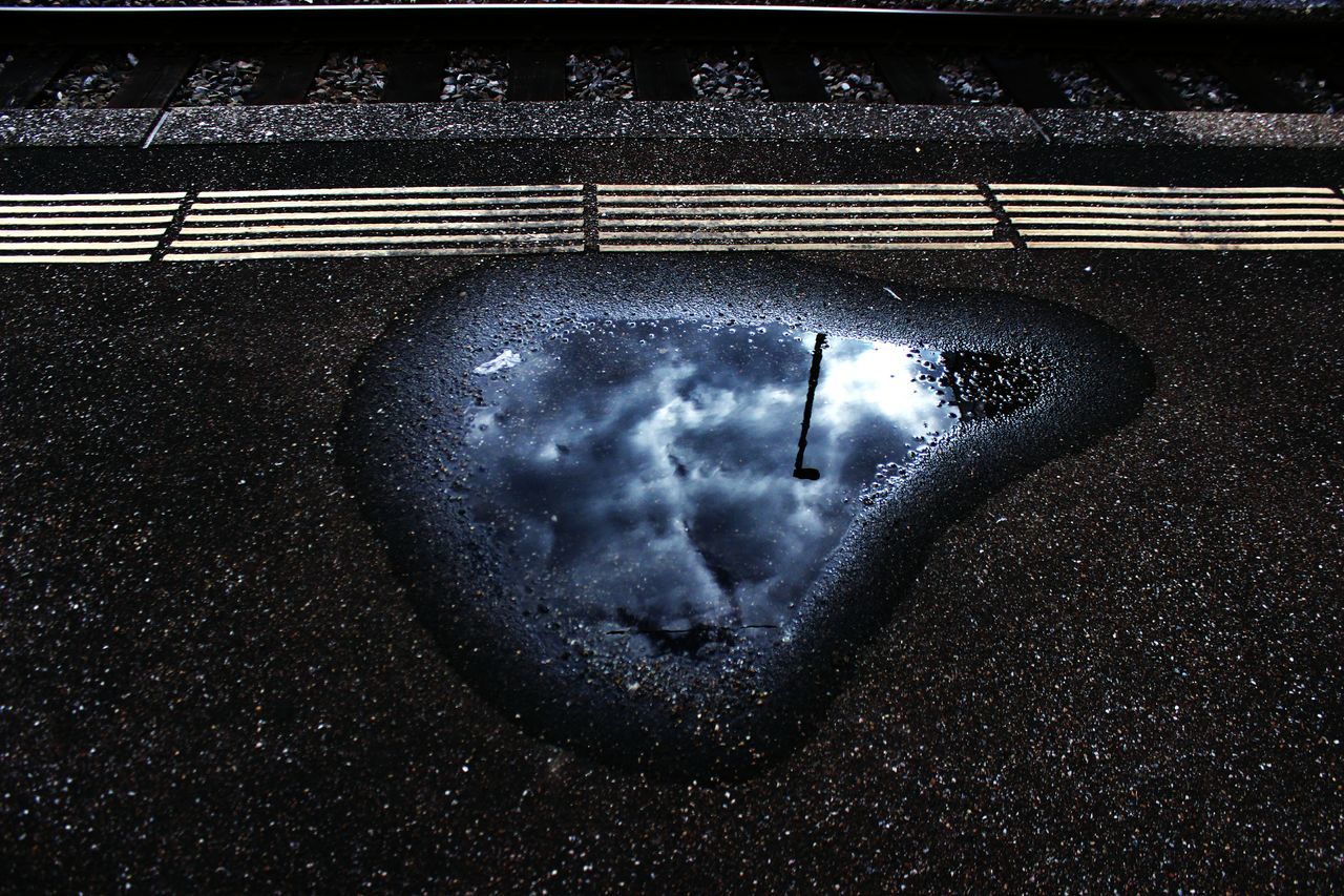 high angle view, water, night, rain, puddle, street, wet, road, reflection, connection, transportation, weather, illuminated, motion, outdoors, season, dark, auto post production filter, silhouette, one person