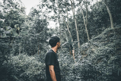 Side view of young man in forest