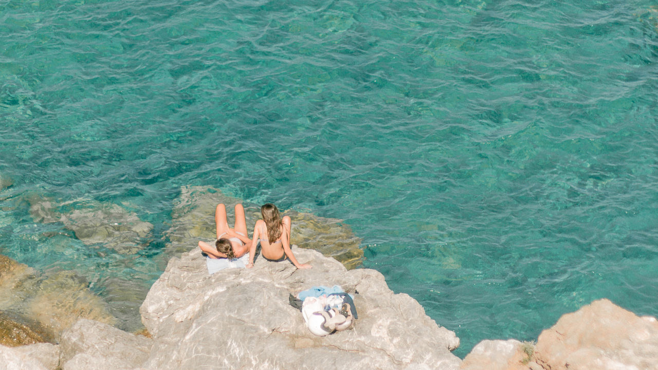 water, high angle view, nature, day, sea, leisure activity, sunlight, beauty in nature, vacation, outdoors, rock, trip, lifestyles, land, holiday, relaxation, swimming, beach, one person, tranquility, ocean