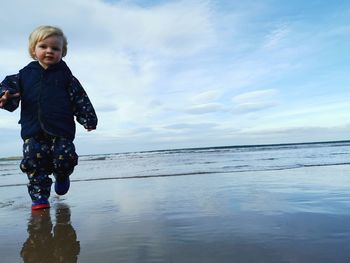 Boy on beach against sky