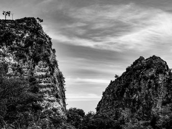 Dramatic two mountain peaks and streaky cloud sky in black and white in ratchaburi thailand