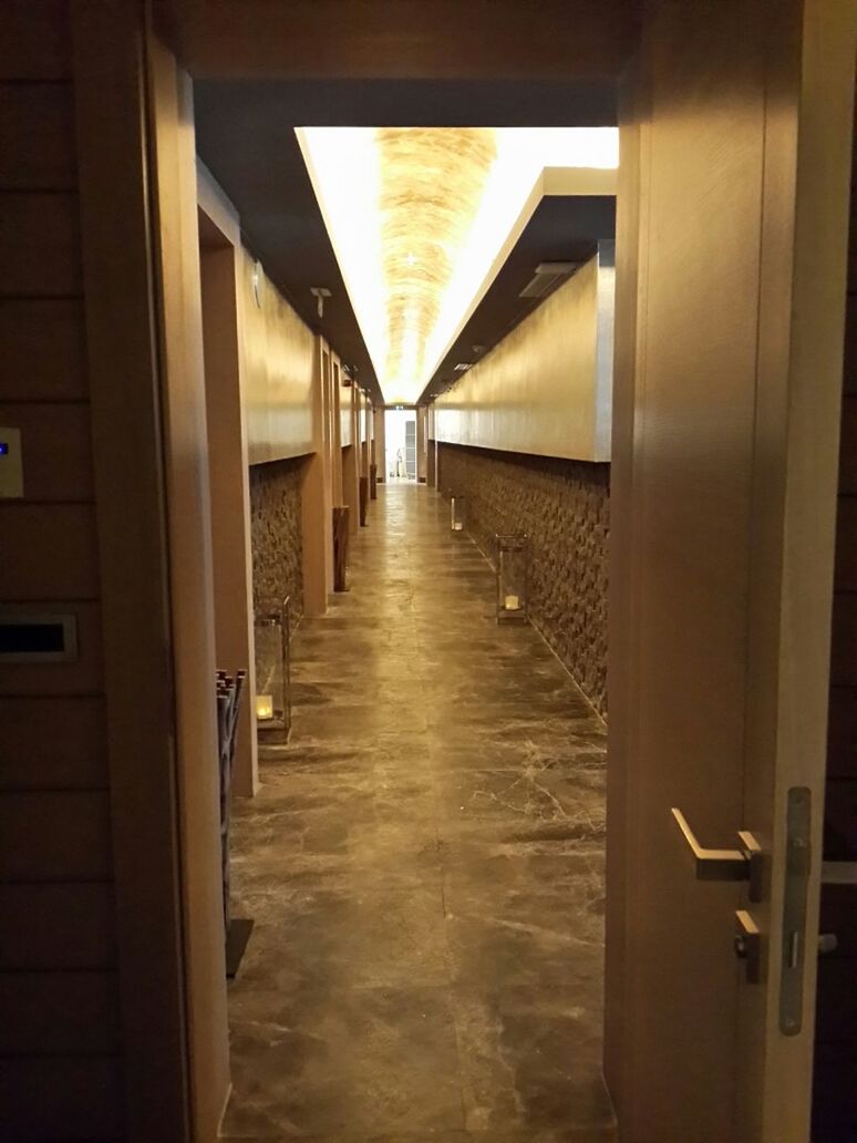 indoors, architecture, corridor, built structure, the way forward, empty, diminishing perspective, architectural column, in a row, ceiling, column, illuminated, flooring, absence, narrow, long, vanishing point, door, lighting equipment, no people