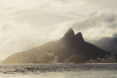 Scenic view of sea and mountains against sky