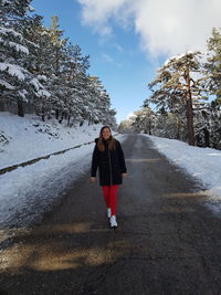 Full length of woman standing on road during winter