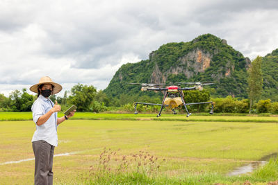 Man standing on field against sky