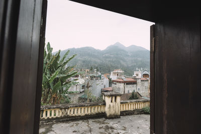 Houses by mountains against sky