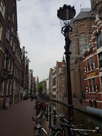 Street by buildings against sky in city