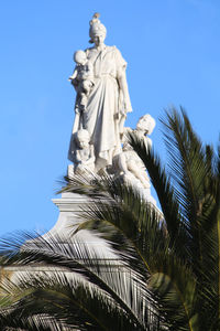 Low angle view of statue against blue sky