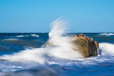 Close-up of wave splashing against clear blue sky