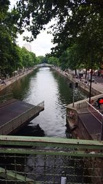 Canal amidst trees against sky