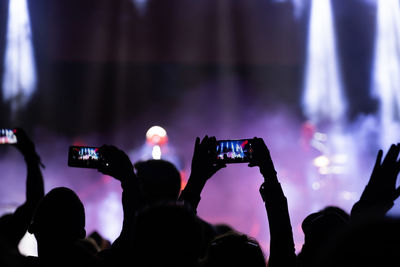 People photographing at music concert