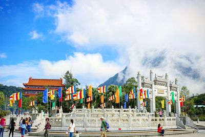 People in city against cloudy sky