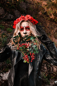 Closeup portrait of calavera catrina. young woman with sugar skull makeup and red flowers. dia de 