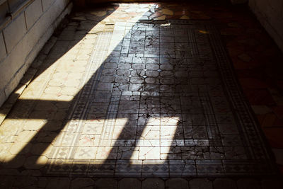 High angle view of shadow on tiled floor