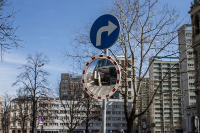 Road mirror and road sign in city