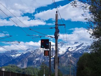 Low angle view of telephone on mountain against sky