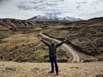 Full length of man with hiking poles standing on land