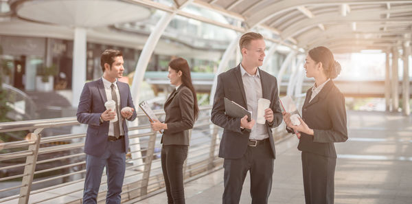 Business people discussing while standing on elevated walkway