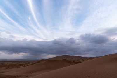 Nature and landscapes of dasht e lut or sahara desert with sand dunes in foreground and cloudy sky 