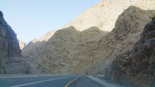 Road amidst rocks against clear sky