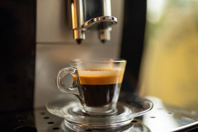 Espresso machine at home - coffee drink in glass cup ready in minute for flavor lovers