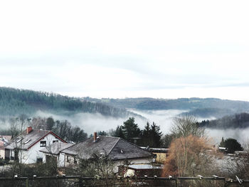 High angle view of houses and trees against sky during winter