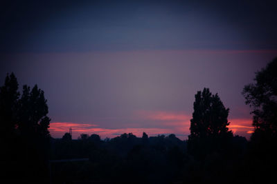 Silhouette trees against sky at sunset