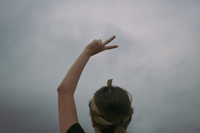 Selective focus ,back view point young women show victory sign over her head, inspiration motivation
