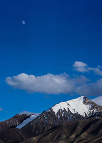 Scenic view of snowcapped mountains against blue sky