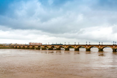 Pont de pierre over garonne river against cloudy sky