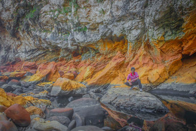 Rear view of woman standing on rock formation