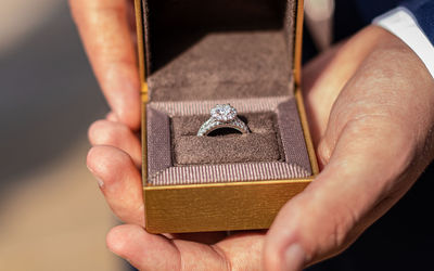 Full frame close-up view of the groom holding the wedding ring box open