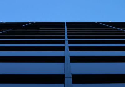 Low angle view of office building against clear blue sky