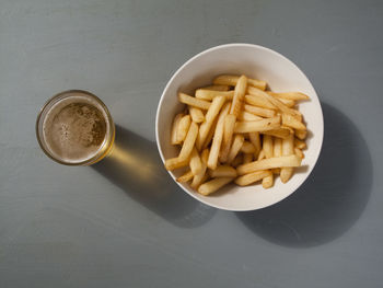 Directly above shot of beer and french fries on table