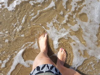 Low section of woman standing on beach