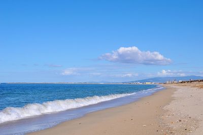 Scenic view of beach against blue sky