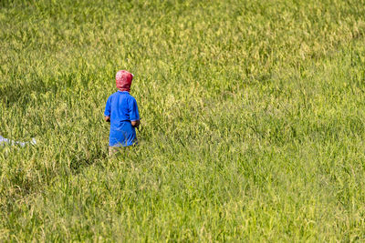 Rear view of woman standing on grassy field