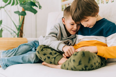 Two brothers boys playing online game, watch video on cellphone. smiling children kids mobile phones