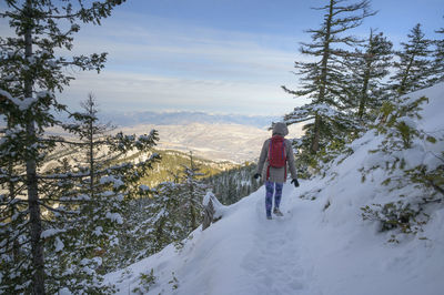 Female hiking down a snowy trail