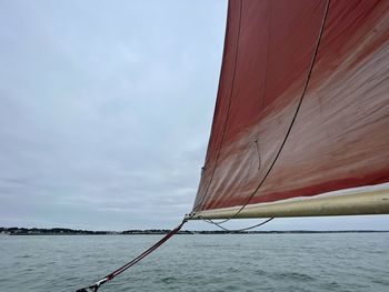 Sailboat sailing on sea against sky