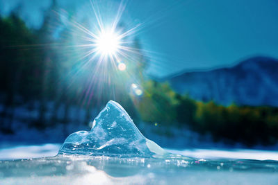 Close-up of water against blue sky on sunny day