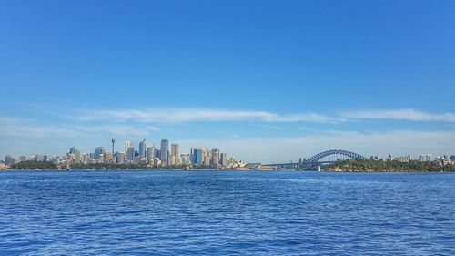 City at waterfront against blue sky