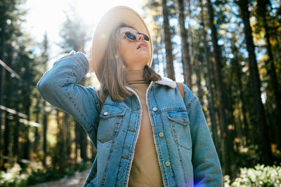 Portrait of young woman standing in forest