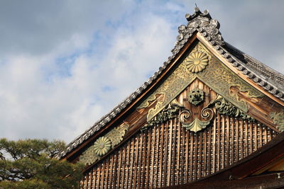 Low angle view of traditional house against cloudy sky